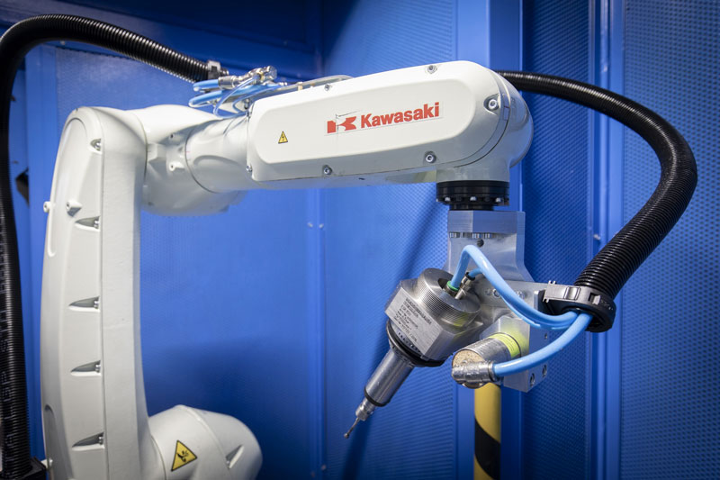 Nella prima cella due robot Kawasaki RS7L–F60, ognuno dotato di due turbine pneumatiche eseguono sia le sbavature nella parte interna del corpo, sia sulla parte esterna.